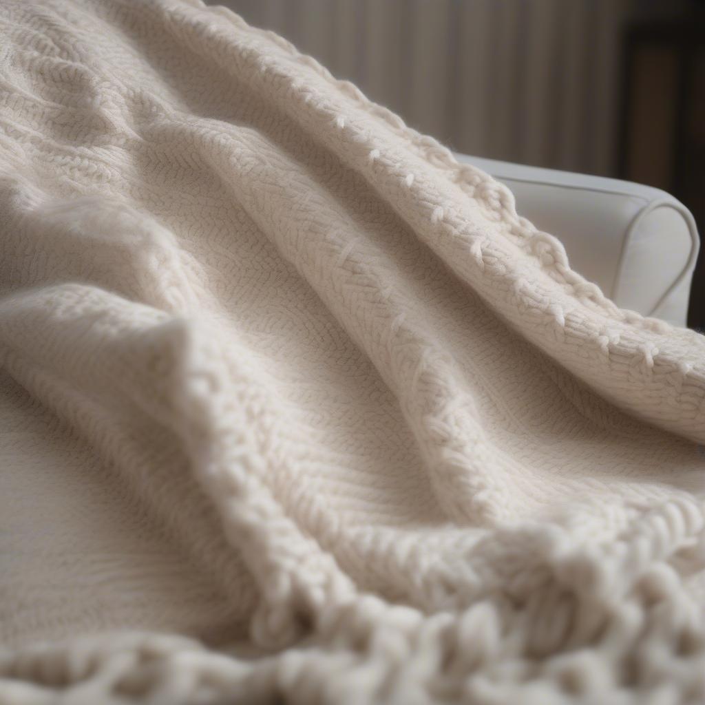 Close-up view of a basket weave knit blanket, showcasing the intricate texture and stitch definition.