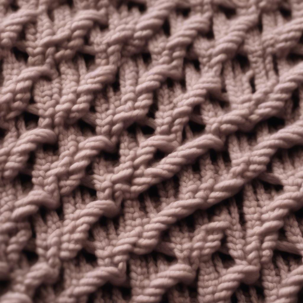 Close-up view of the basket weave knitting stitch showing the interplay of knit and purl stitches creating the textured pattern.