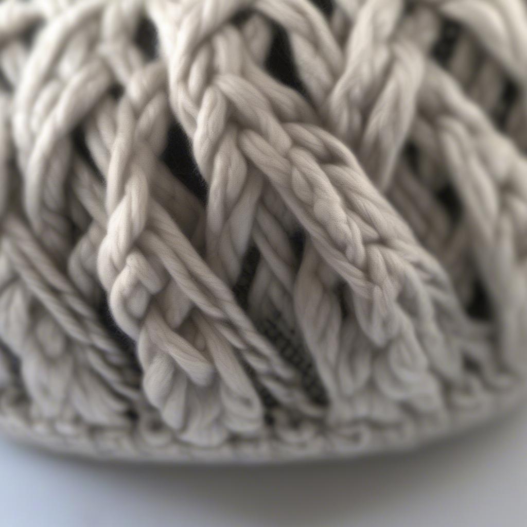 Close-up view of a finished Celtic weave messy bun hat, showcasing the intricate knit pattern and the comfortable, stylish design.