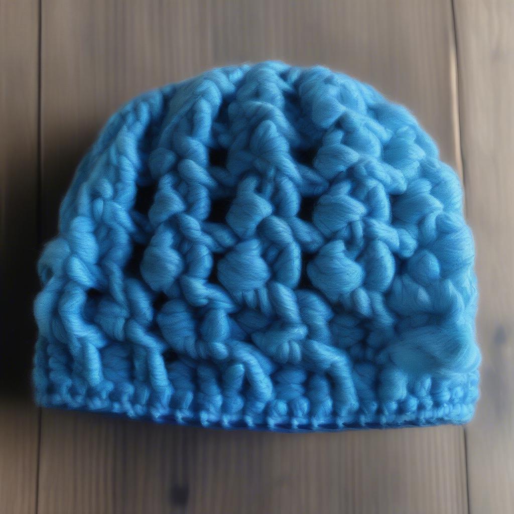 Close-up of a child's basket weave crochet hat, showcasing the intricate stitch detail and soft yarn texture.