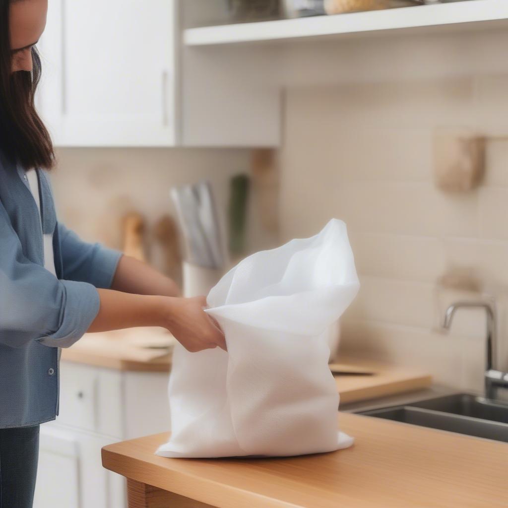 A person cleaning a non-woven grocery bag with a damp cloth.