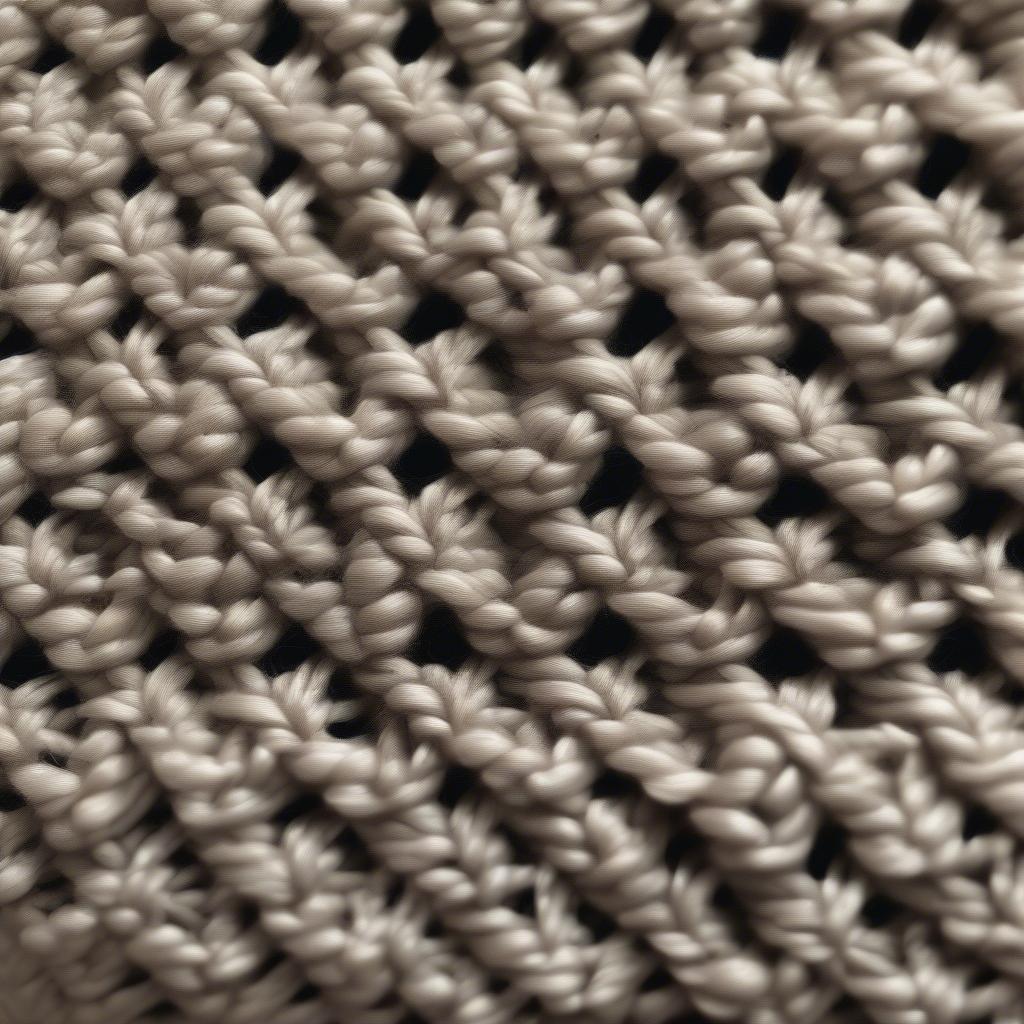 Close-up view of a crochet basket weave stitch showing the textured detail and interwoven appearance.