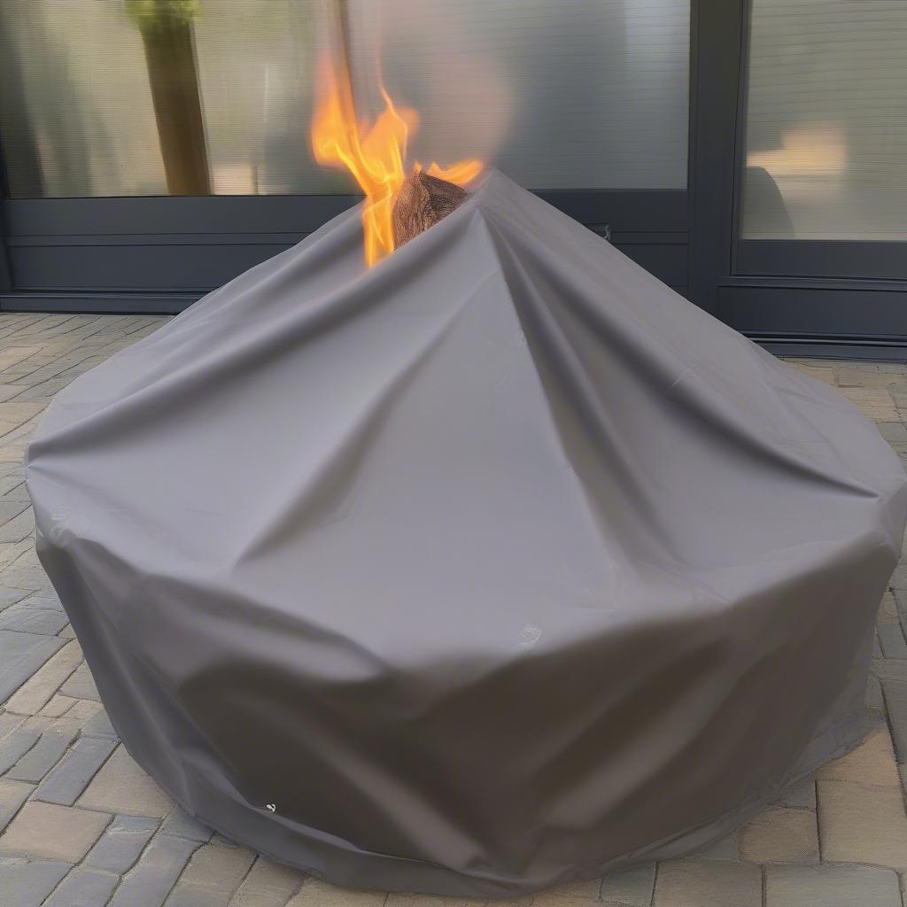 Elements 72" fire table covered with a protective cover.