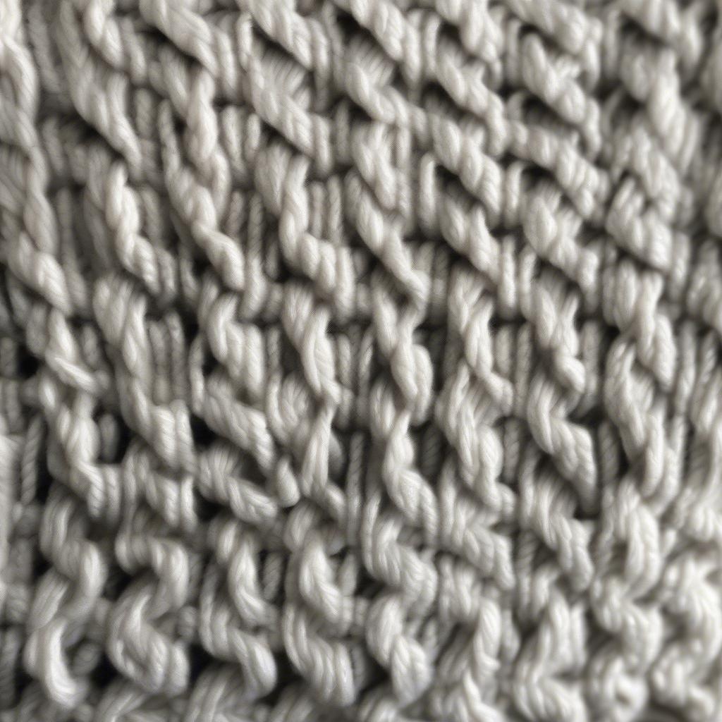 Close-up of a hand-knitted basket weave hat, showcasing the intricate texture and stitch definition.