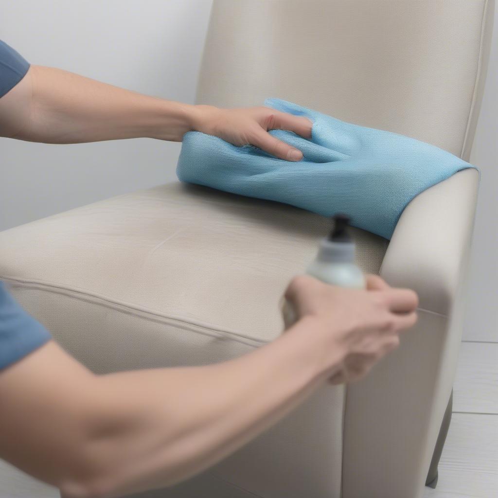 Someone cleaning a vinyl weave chair with a cloth and cleaning solution.