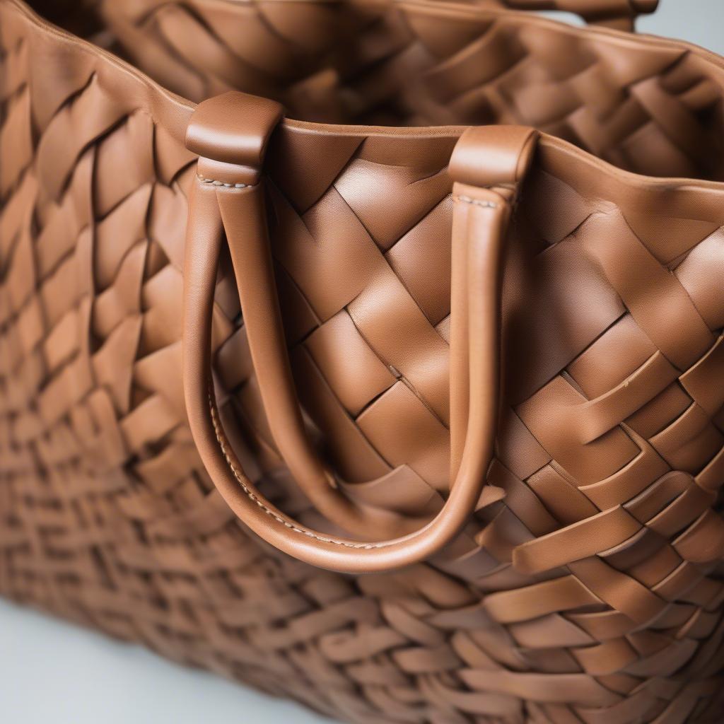 Close-up of a woven leather tote bag showcasing the intricate craftsmanship and the beautiful texture of the leather.