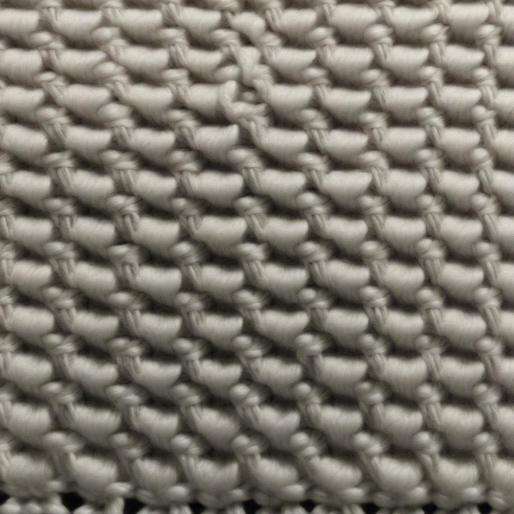 Close-up of a 13-needle basket weave knit swatch showing the distinct checkered pattern and textured fabric.