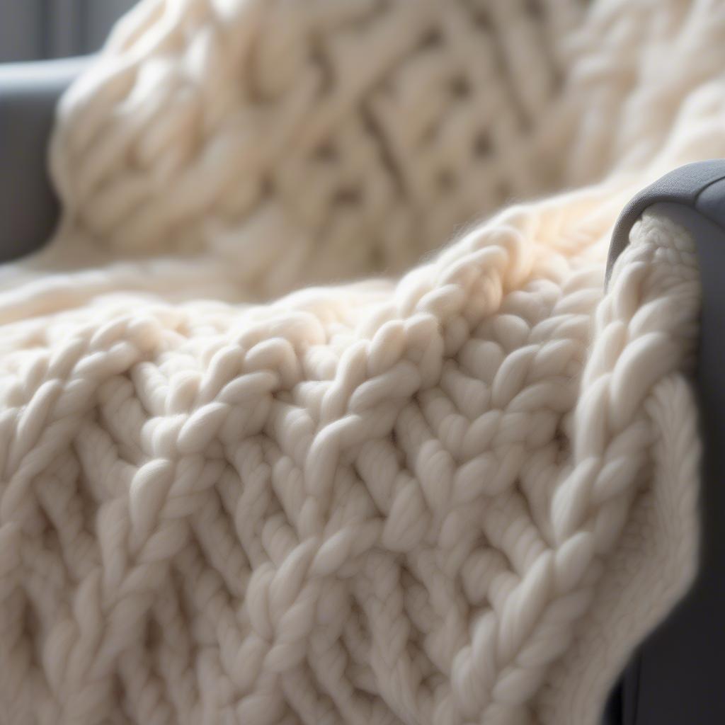 Close-up view of a chunky basket weave arm knit blanket showcasing the intricate texture and stitch definition.