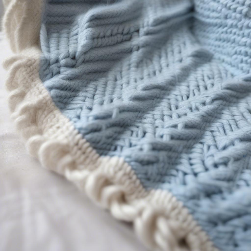 Close-up view of a finished basket weave baby blanket, showcasing the detailed texture and stitch pattern