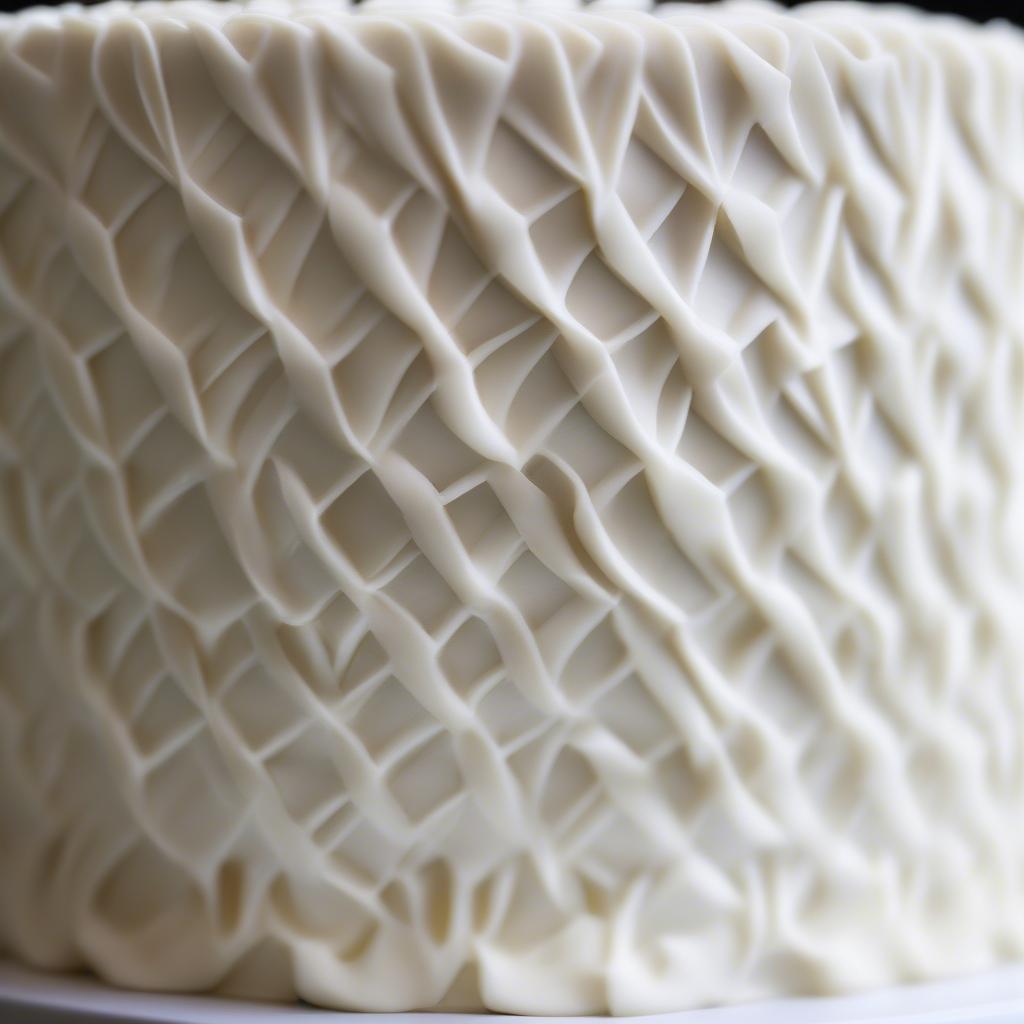 Close-up of a beautifully executed basket weave cake border on a two-tiered cake.