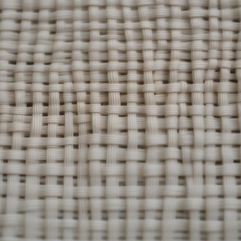 Close-up view of basket weave fabric showing the interlacing of yarns and the characteristic checkered pattern.