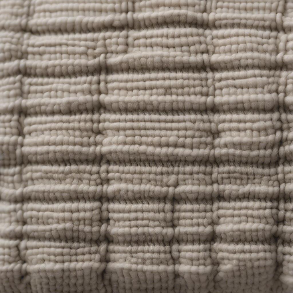 Close-up view of a basket weave knit pillow showcasing the intricate texture and stitch definition.