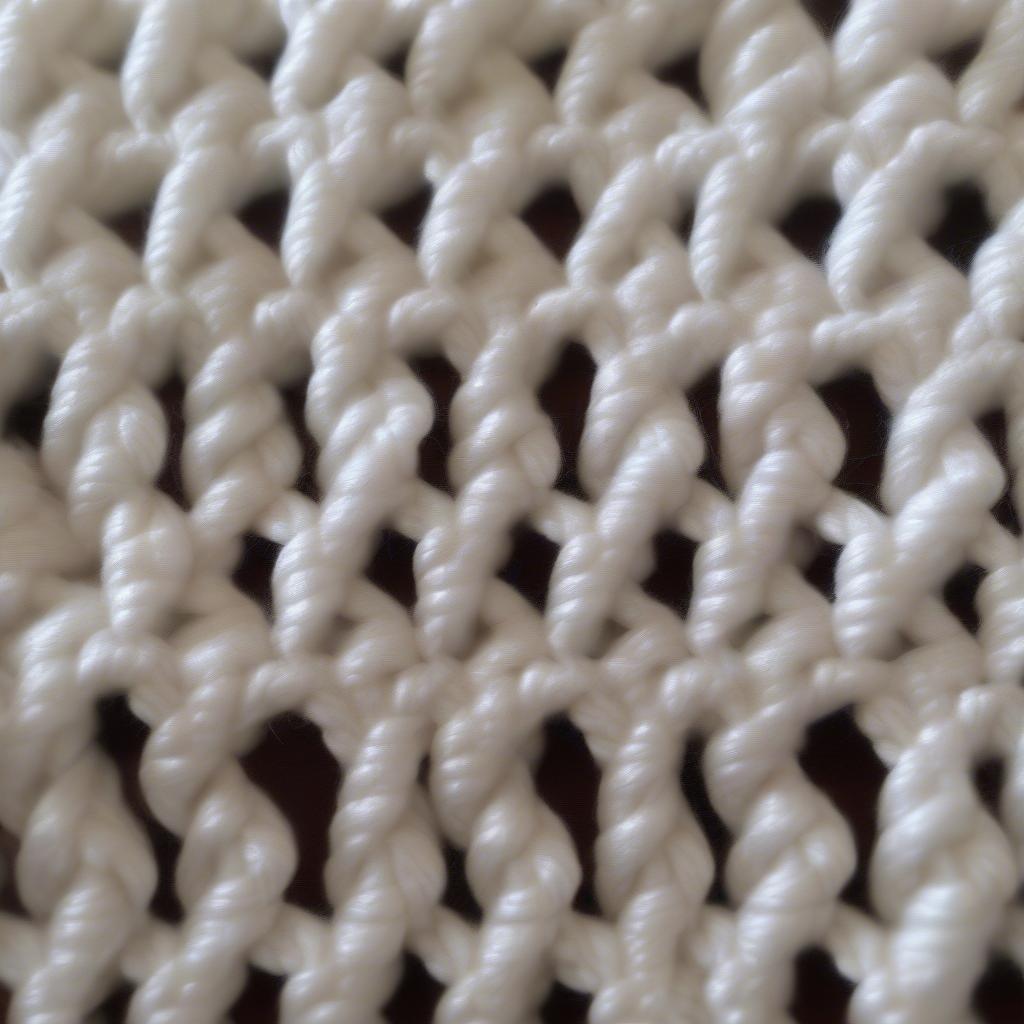 Close-up of Cheryl Chow's basket weave preemie blanket, showcasing the intricate details of the stitch and the soft yarn.