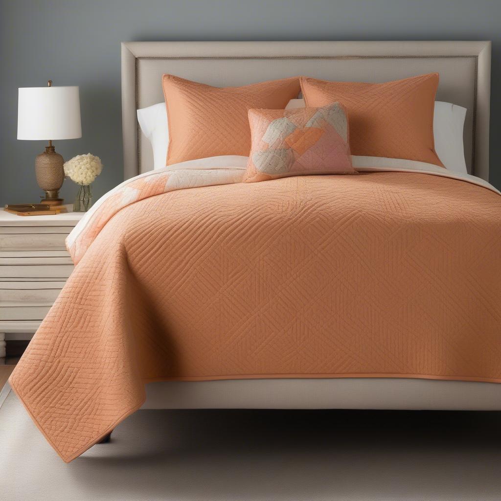 The Bentley Apricot Brandy Basket Weave Quilt styled on a bed with coordinating decorative pillows, demonstrating how to incorporate it into a bedroom setting.