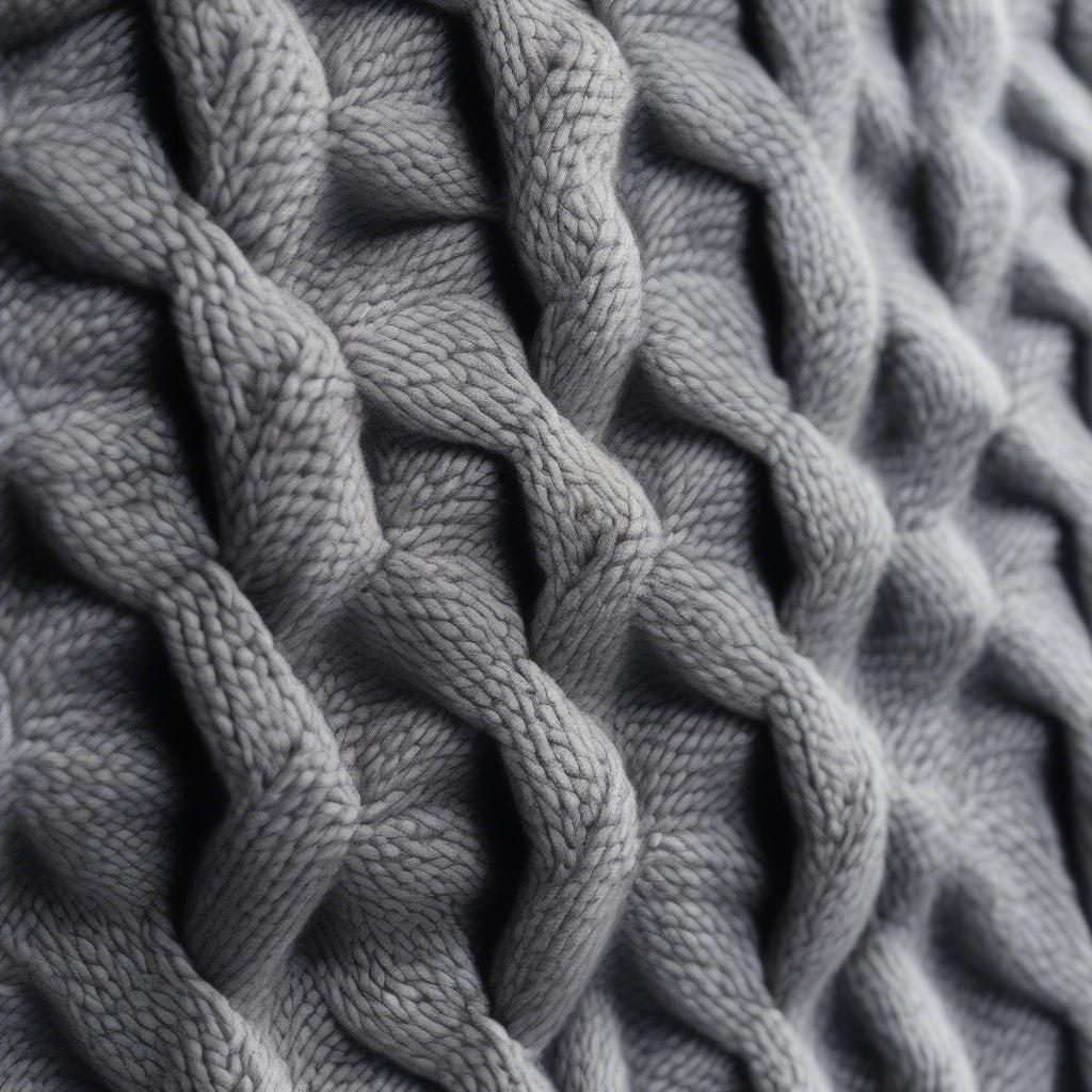 Close-up of a gray basket weave sweater, showcasing the intricate texture and knit.