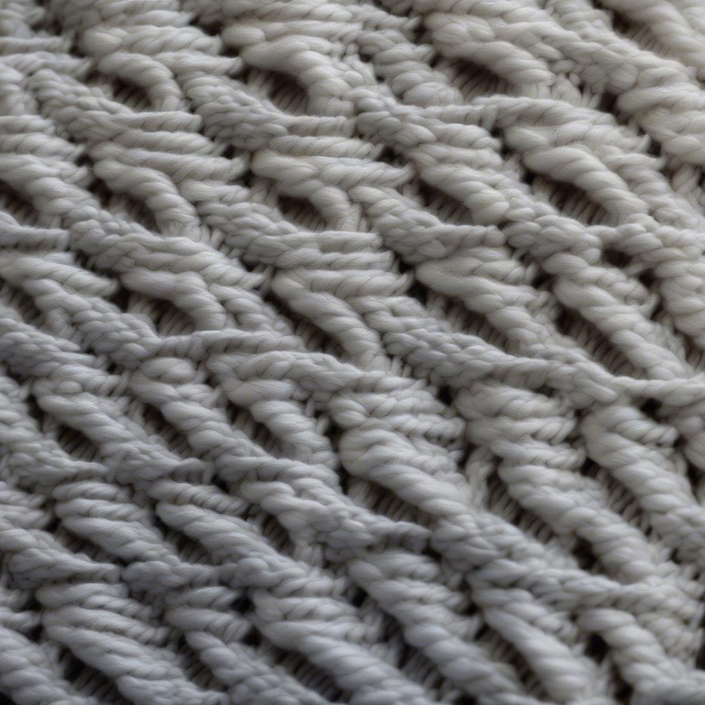 Close-up of the knitted basket weave stitch showing the alternating knit and purl blocks.