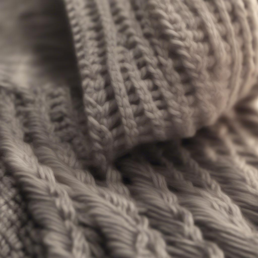 Knitting needles and yarn being used to create a basket weave beanie, showing the process of creating the stitch.