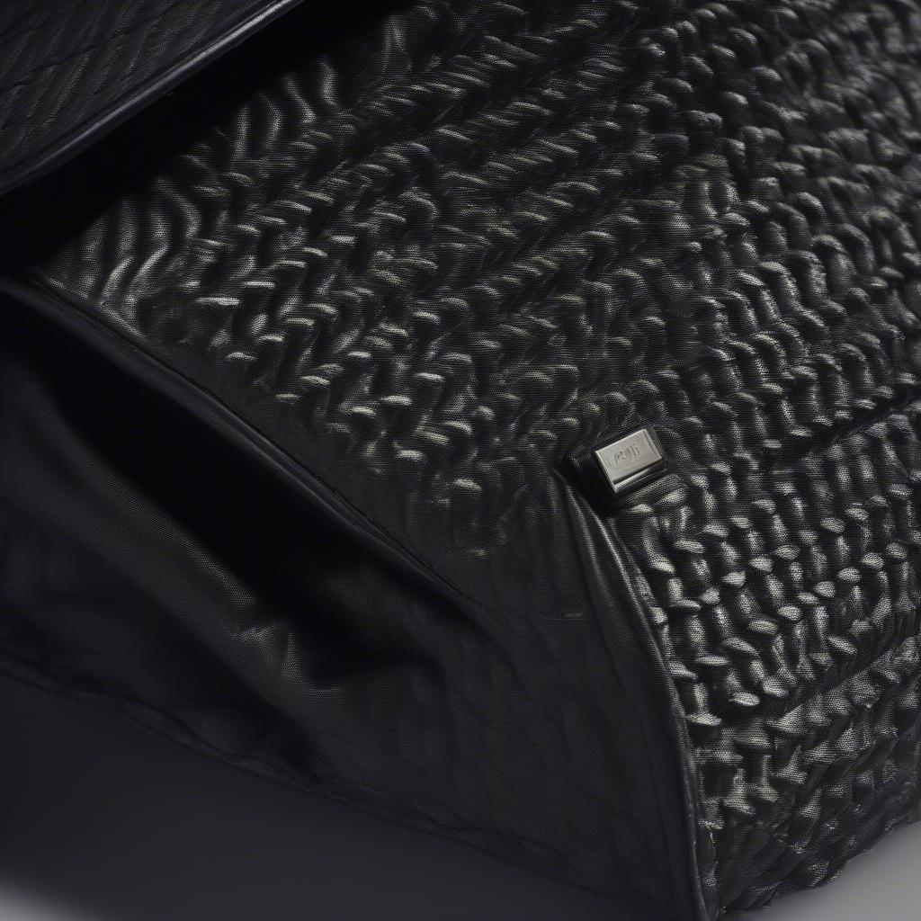 Close-up view of the Kurt Geiger black woven effect tote bag, showcasing the intricate woven pattern and the high-quality material.