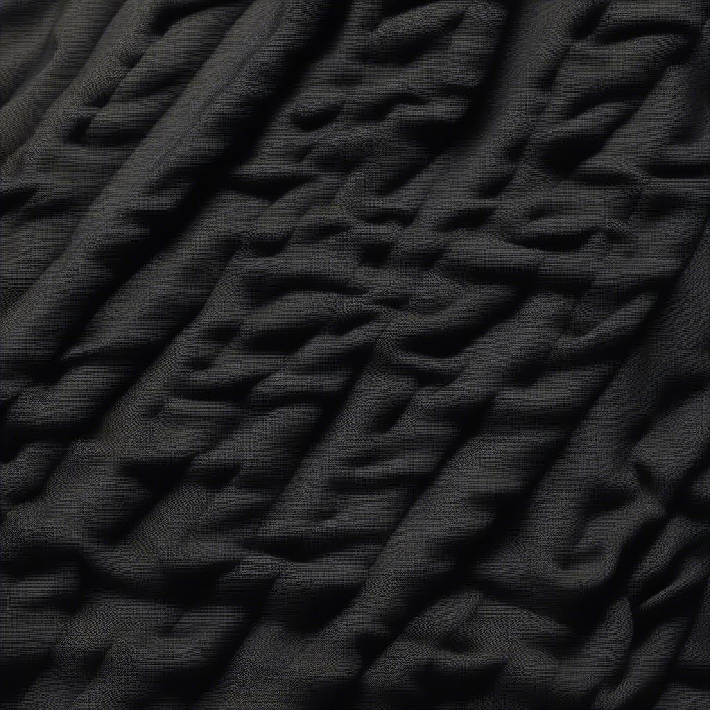 Close-up view of the black basket weave pattern on the Our Legacy Classic Coat