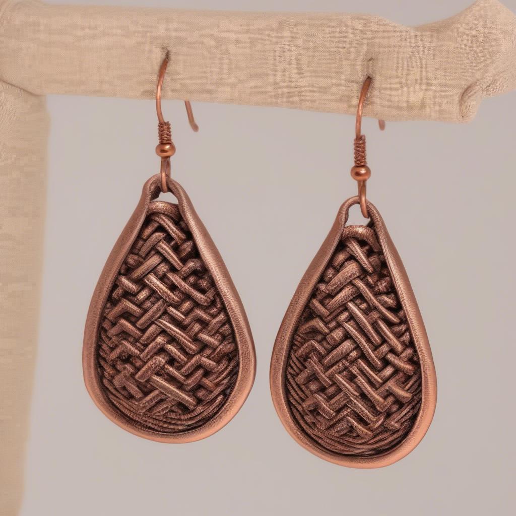 A pair of paparazzi basket weave copper earrings with a unique, eye-catching design.