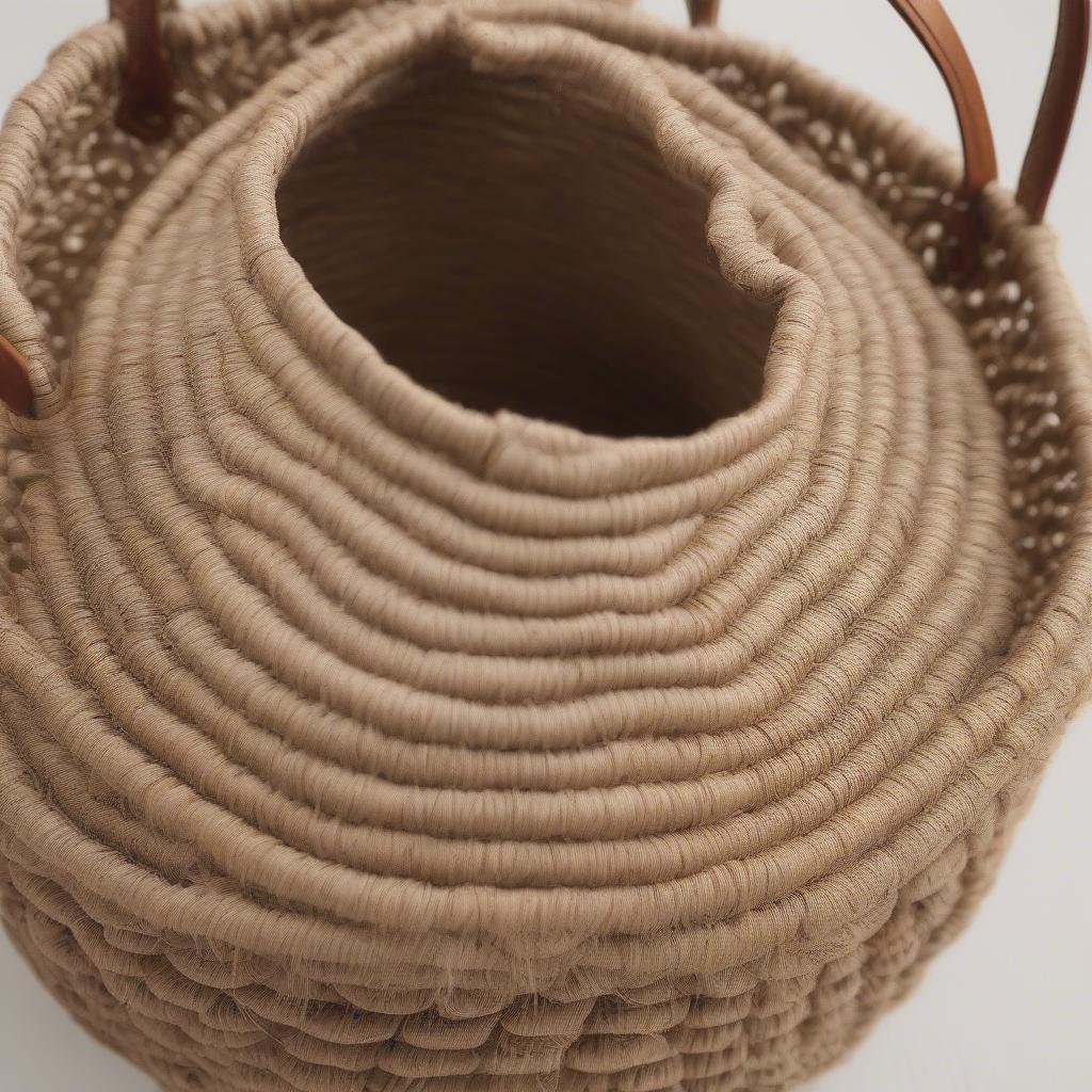 Round woven tote bag made from natural fibers like seagrass and jute.