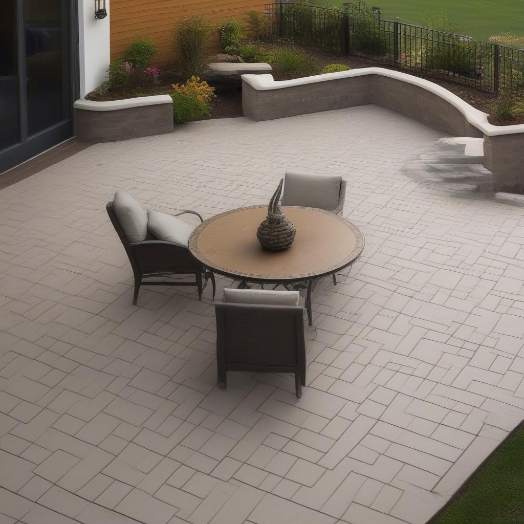 A beautifully sealed concrete basket weave patio with furniture