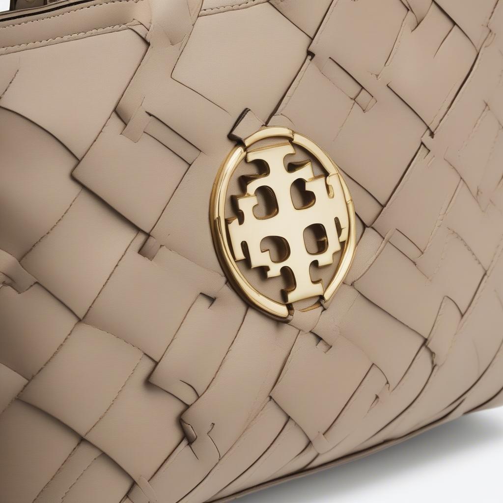 Close-up view of the Tory Burch Robinson Basket Weave Tote, showcasing the intricate leather basket weave pattern and the gold-tone logo.