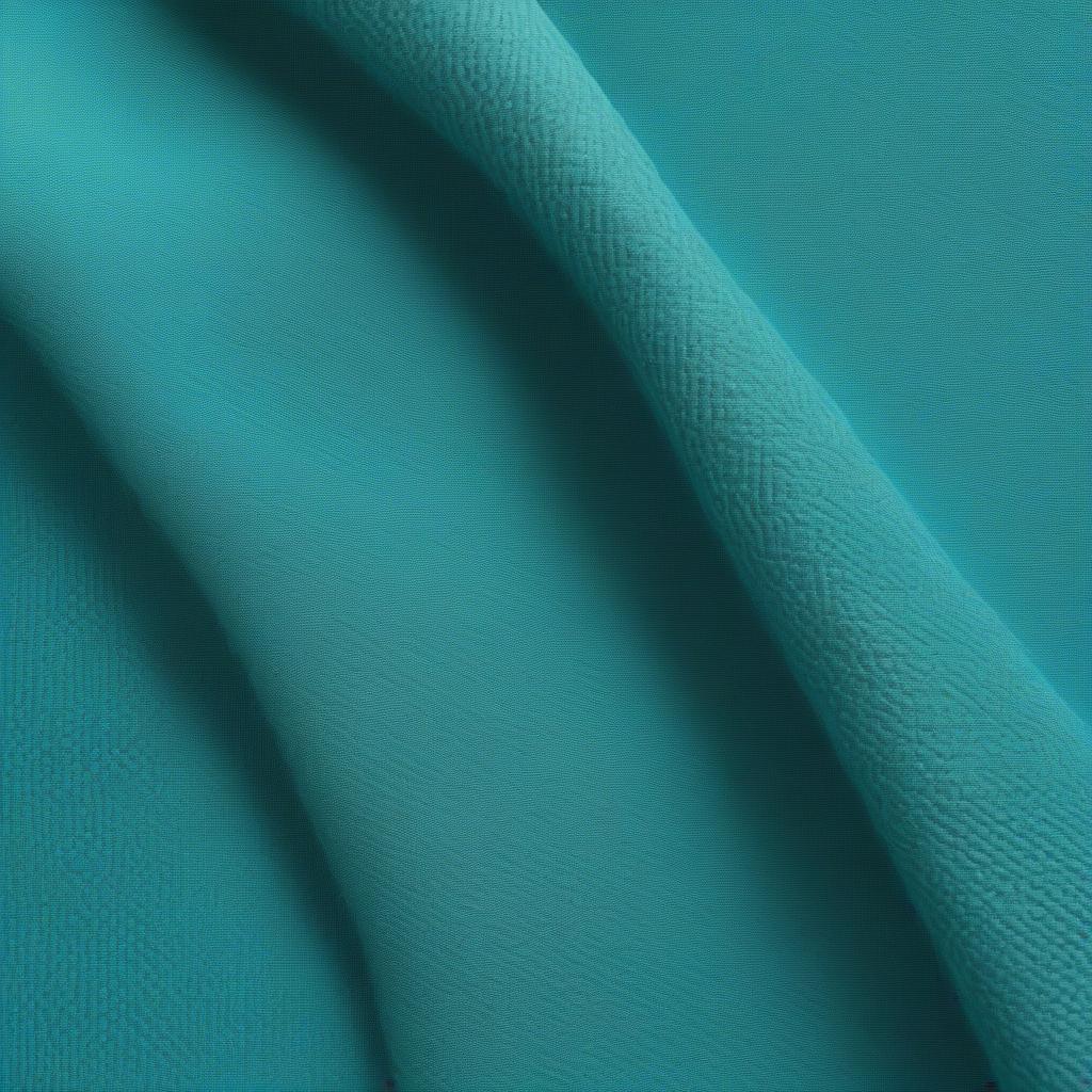 Close-up view of the turquoise slub weave fabric on an English arm chair