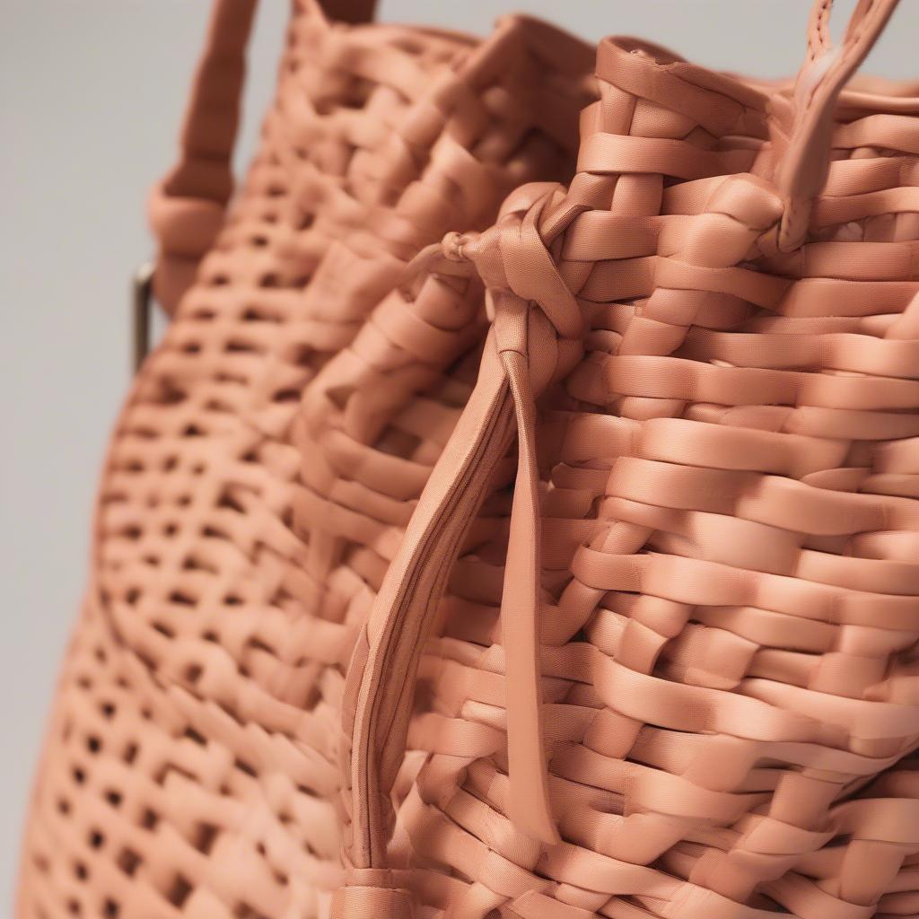 Close-up view of the Westlyn Woven Bucket Bag in Peach showcasing the intricate weaving detail and natural peach hue.