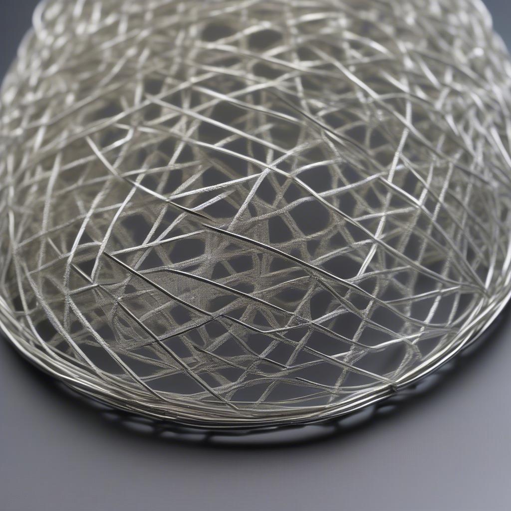 Close-up of a wire basket weave pendant showcasing the intricate details of the weave and the shimmering silver wire.