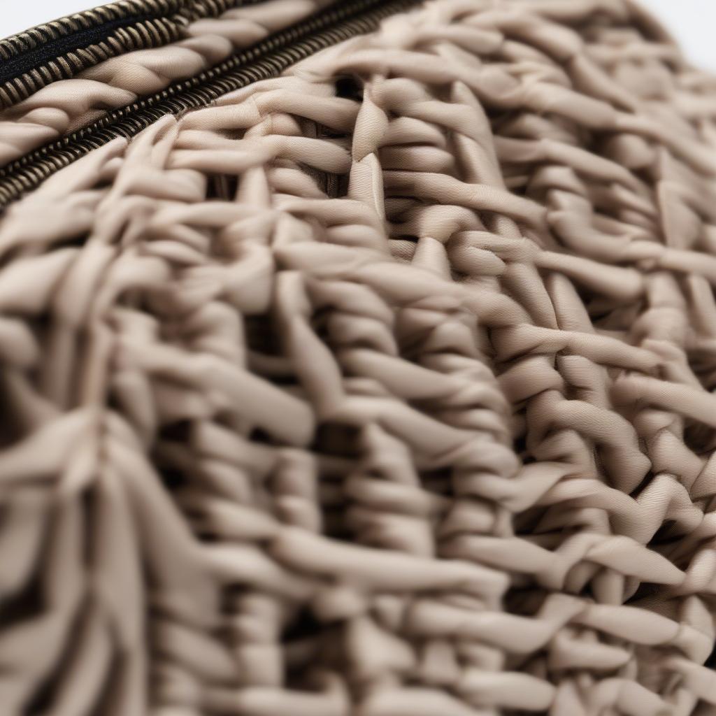 Woven clutch bag with zip, close-up view showcasing the intricate weaving and secure zipper closure.