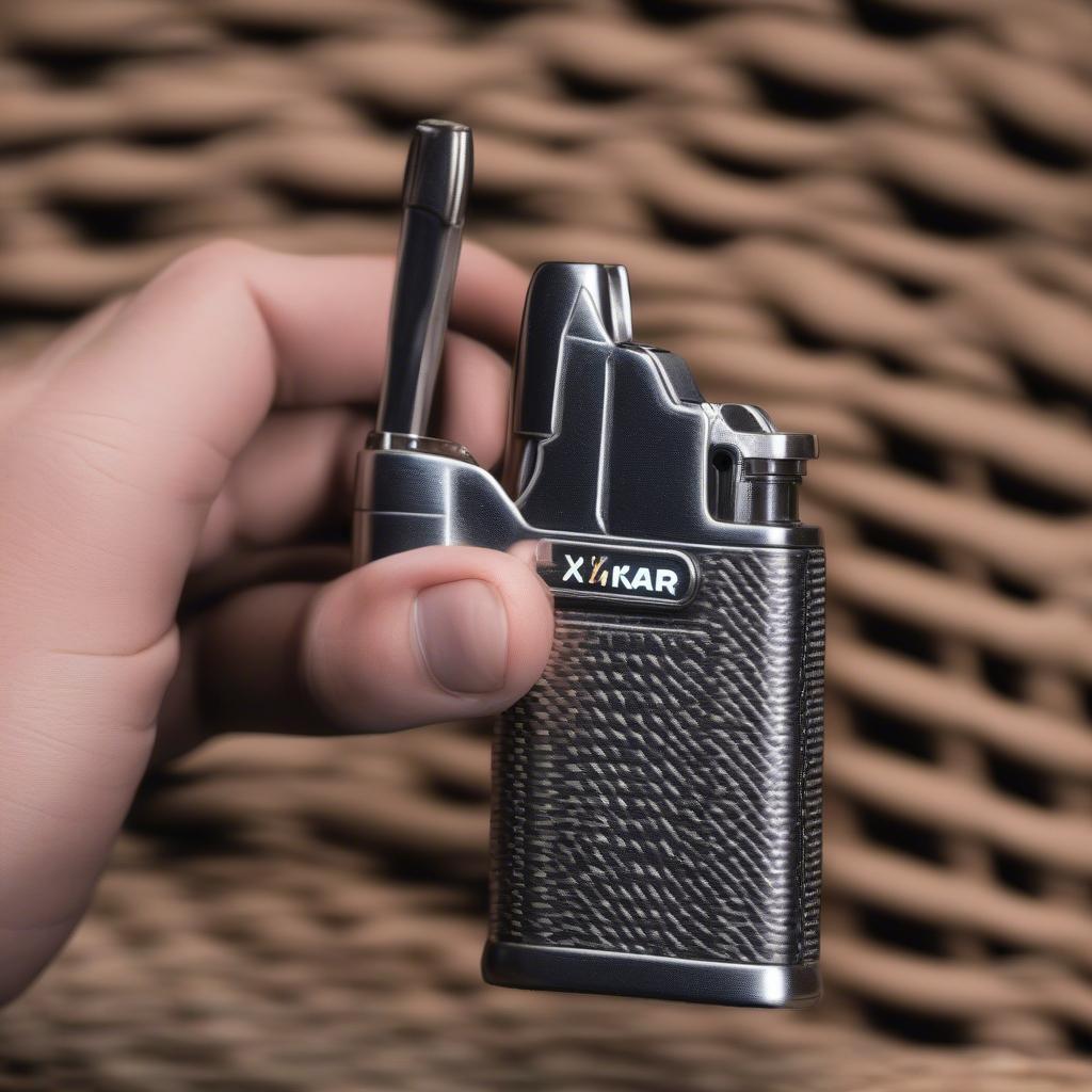 Hand holding the Xikar FlintFire II lighter, demonstrating its grip and size.